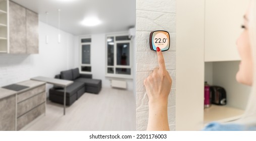 Young Woman Controlling Home With A Digital Touch Screen Panel Installed On The Wall In The Living Room. Concept Of A Smart Home And Mobile Application For Managing Smart Devices At Home