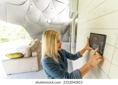 Young woman controlling home light with a digital tablet in the glamping dome tent. Concept of a smart home and light control with mobile devices - Shutterstock ID 2312042815