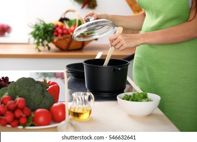 Young Woman Is Cooking By The Stove In The Kitchen, Close Up. 