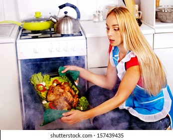 Young Woman Cooking Chicken At Kitchen.