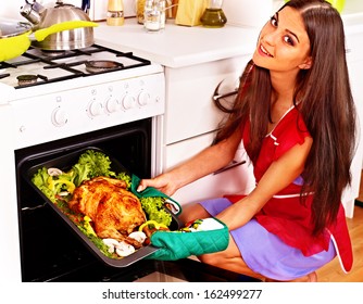 Young Woman Cooking Chicken At Kitchen.