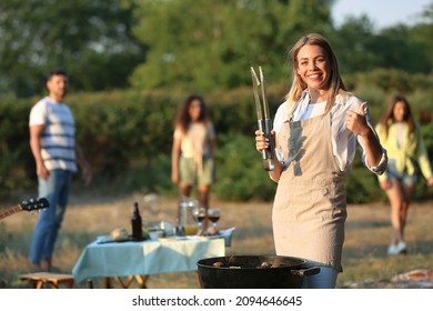 Young Woman Cooking Food On Barbecue Grill Outdoors