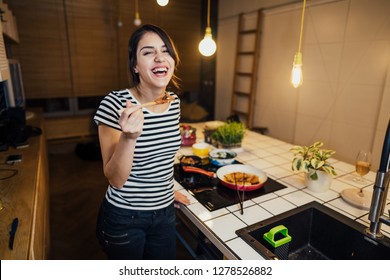 Young Woman Cooking A Healthy Meal In Home Kitchen.Making Dinner On Kitchen Island.Preparing Fresh Meal,enjoying Spice Aromas.Eating In.Passion For Cooking.Healthy Lifestyle And Dieting Concept.