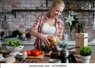 Young Woman Cooking In Kitchen. Beautiful Woman Making Delicious Food. 