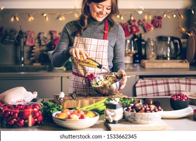 Young Woman Cooking In The Kitchen. Healthy Food For Christmas (stuffed Duck Or Goose)