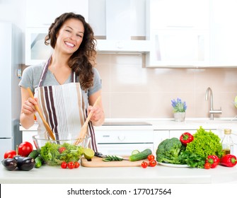 Young Woman Cooking in the kitchen. Healthy Food - Vegetable Salad. Diet. Dieting Concept. Healthy Lifestyle. Cooking At Home. Prepare Food  - Powered by Shutterstock