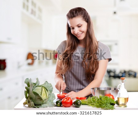 Young Woman Cooking in the kitchen. Healthy Food - Vegetable Salad. Diet. Dieting Concept. Healthy Lifestyle. 