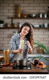 Young Woman Cooking In The Kitchen.  Woman Cooking Pasta Dish.