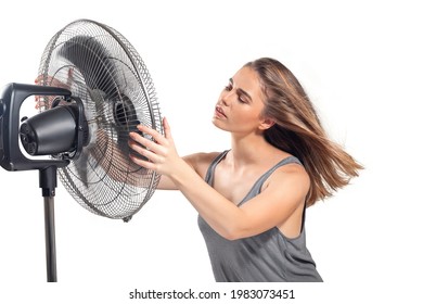 Young Woman Cooling Down With Electric Fan In Hot Summer Isolated On White Background