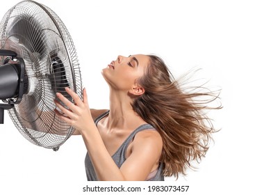 Young Woman Cooling Down With Electric Fan In Hot Summer Isolated On White Background