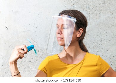 Young Woman Cooling Down With Hand Held Ventilator While Wearing A Protective Visor