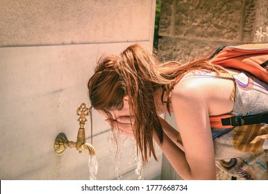 A Young Woman Cooling Off By Washing Her Face At The Street Fountain In Summer Heat, Closeup.