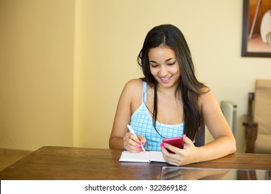 Young Woman Copying Her Contact List Into A Book.