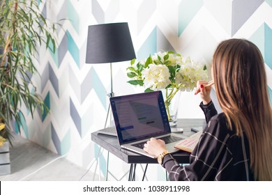 Young Woman Copywriter Working On Web Site Via Laptop Computer Sitting In Home Interior. Hipster Girl Skilled Administrator Of Social Networking Groups Using Net-book Resting In Cafe Bar. Homepage 