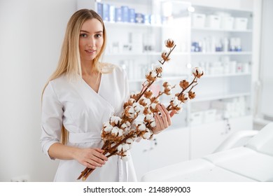 Young Woman With Cotton Plant Standing In Beauty Salon