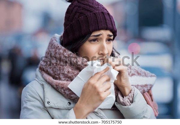 通りで冬に咳をする若い女性 ニットの帽子をかぶった冷たい女の子とスカーフの感じが悪い 冬と都市の汚染に悩む女性 喉が痛い女の子 の写真素材 今すぐ編集