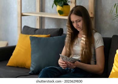 Young Woman Is Counting Money And Is Saddened By The Expenses. Girl Recounts Her Salary. Low Salary. Inflation