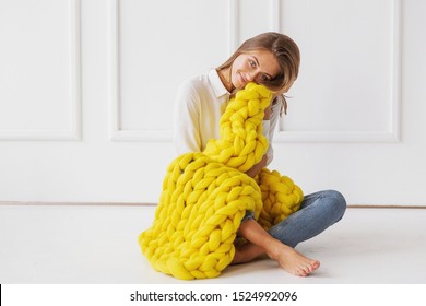 Young Woman Covered With Chunky Merino Wool Blanket On White Background. Cozy Winter Style.