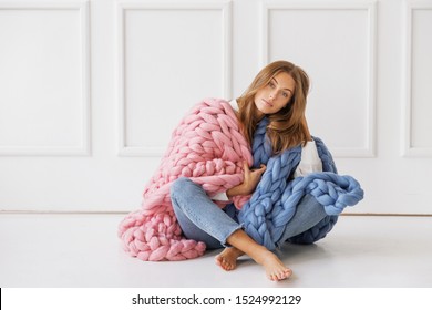 Young Woman Covered With Chunky Merino Wool Blanket On White Background. Cozy Winter Style.