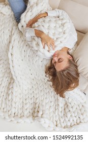 Young Woman Covered With Chunky Merino Wool Blanket On White Background. Cozy Winter Style.