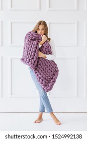 Young Woman Covered With Chunky Merino Wool Blanket On White Background. Cozy Winter Style.