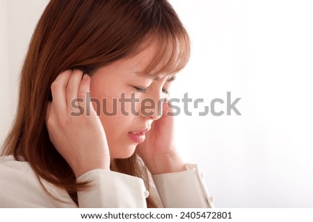 A young woman covering her ears