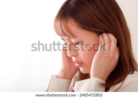 A young woman covering her ears