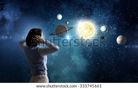 Young woman covering her ears with hands and looking at space planets