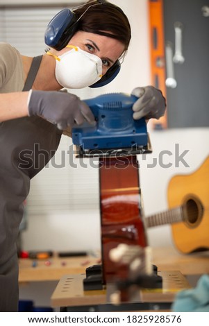 young woman crafting a guitar