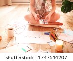 Young woman creating her Feng Shui wish map using scissors. Dreams and wishes