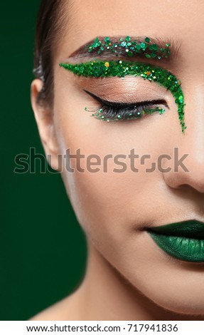Young woman with creative makeup on color background, close up