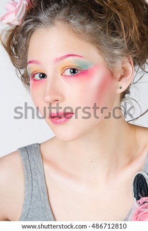 Young woman with creative make-up posing in a studio 