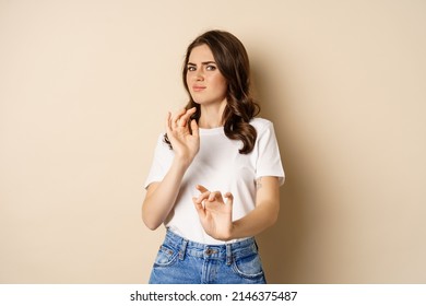 Young Woman Cringe, Shaking Hands To Decline, Reject Disgusting Bad Offer, Standing Over Beige Background