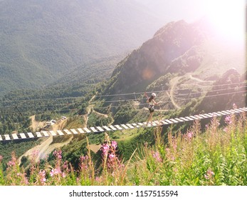 Young Woman Crossing The Chasm On The Rope Bridge, Sochi, Russia