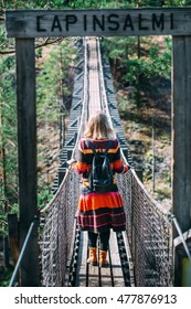 Young Woman Crossing The Chasm On The Rope Bridge