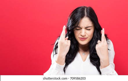 Young woman crossing her fingers and wishing for good luck - Powered by Shutterstock