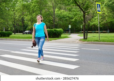 Young woman crossing the road - Shutterstock ID 285627476