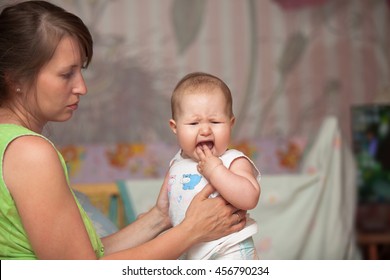 A Young Woman With A Crying Baby Due To Teething