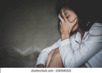A young woman crying and covering her face. depression or domestic violence. The concept of sexual harassment against women and rape.  human trafficking,  international women's day.
