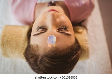 Young Woman At Crystal Healing Session In Therapy Room