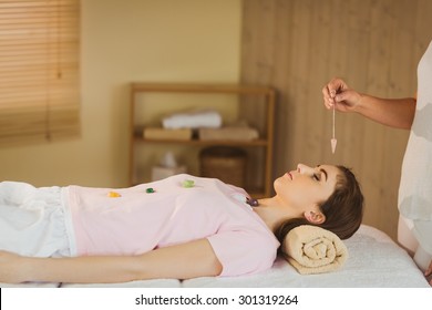 Young Woman At Crystal Healing Session In Therapy Room