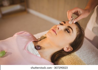 Young Woman At Crystal Healing Session In Therapy Room