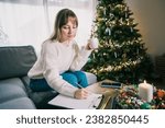 Young Woman with cup is hand writing New year