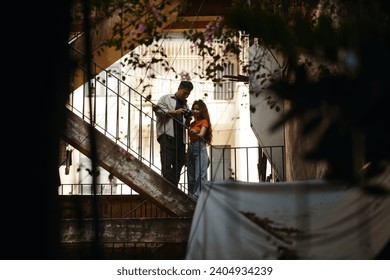 Young woman with curly hair asking photographer to show pictures on screen of digital camera - Powered by Shutterstock