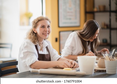 Young woman curving clay product edges Pottery workshop. - Powered by Shutterstock