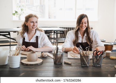 Young woman curving clay product edges Pottery workshop. - Powered by Shutterstock