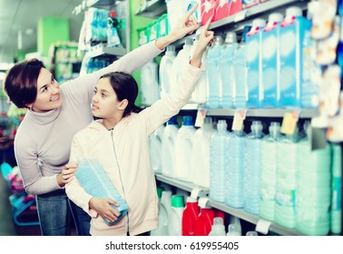 Young woman customer with girl looking for a cleaners for home in supermarket. Focus on child - Shutterstock ID 619955405