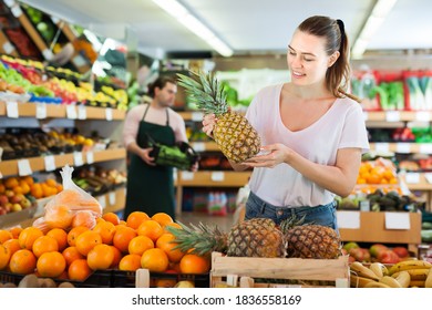 Young woman customer holding fresh pineapple in hands on the supermarket - Shutterstock ID 1836558169