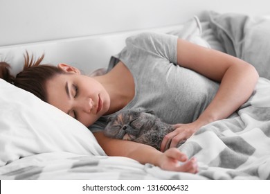 Young Woman With Cute Cat Sleeping In Bed