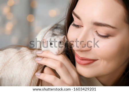 Young woman with cute rat at home, closeup